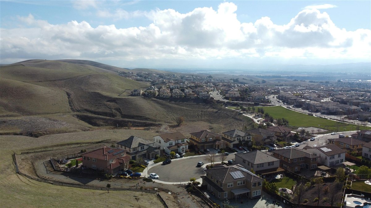 Drone view of Yucaipa hillside neighborhood with homes and the San Bernardino Valley stretching into the distance